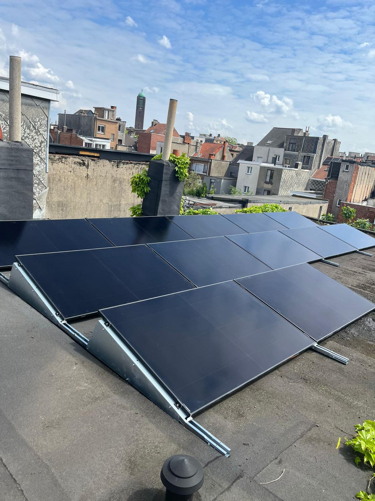 Zonnepanelen op een stadsdak met uitzicht over de stad